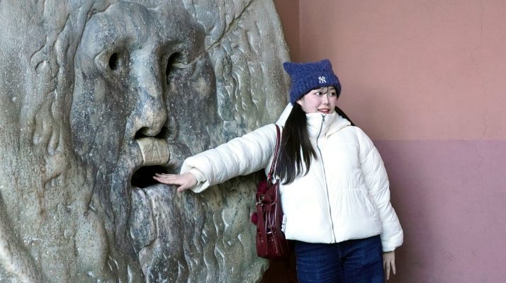 Tourist placing hand in the Mouth of Truth in Rome