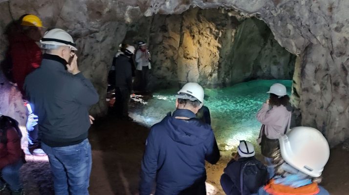 Visitors exploring subterranean lake in underground quarry galleries at the Temple of Claudius