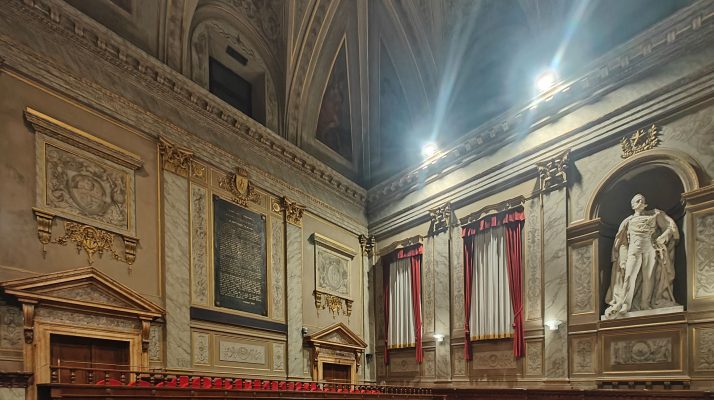 Interior view of a grand hall within Palazzo Valentini, featuring ornate architecture and a statue.