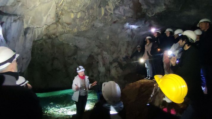 Tour group exploring subterranean lake in Temple of Claudius quarry galleries